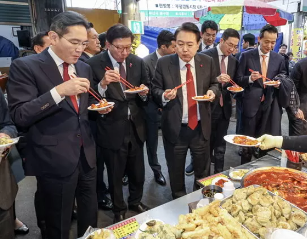윤석열 전 대통령과 함께 국내 주요 대기업 총수들이 부산 깡통시장을 방문해 떡볶이를 먹는 모습. 이재용 삼성전자 회장(맨 왼쪽)의 어묵 국물 사랑 뿐만 아니라 김동관 한화그룹 부회장(맨 오른쪽)의 모습에도 많은 관심을 보였다. / 대통령실