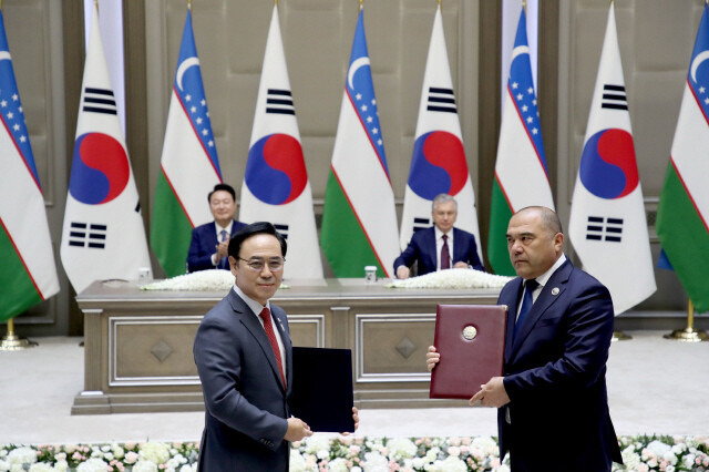 우즈베키스탄 대통령궁에서 2024년 6월14일(현지시각) 열린 양해각서(MOU) 서명식에서 이용배 현대로템 사장(왼쪽)과 주파르 나르줄라예프 우즈베키스탄 철도공사 사장이 ‘우즈베키스탄 철도공사 고속철 6편성 공급계약’에 서명한 뒤 기념사진을 찍고 있다. / 대통령실