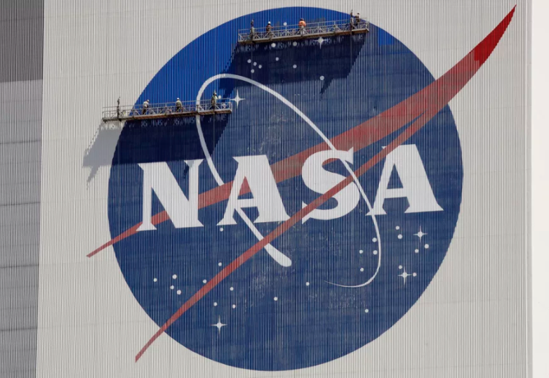 플로리다주 케이프 커내버럴의 케네디 우주 센터에서 작업자들이 NASA 로고를 수리하고 있다. / npr.org