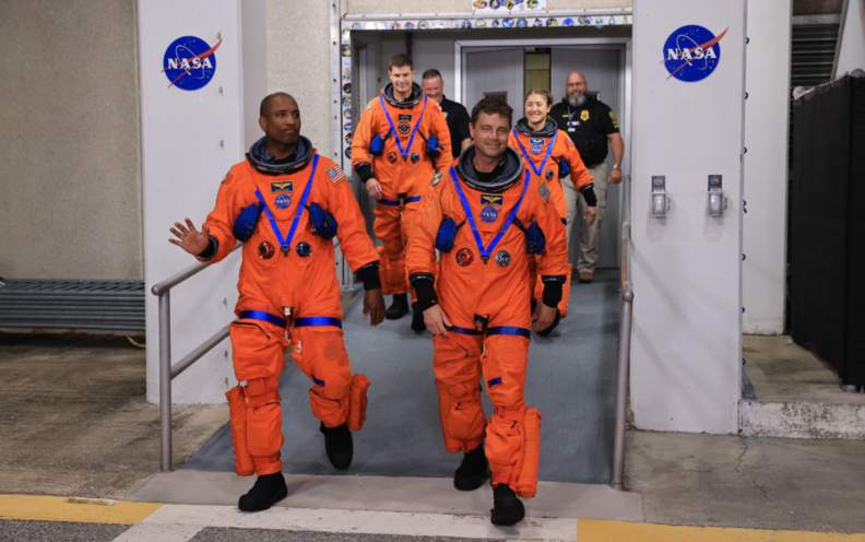 NASA 우주비행사 빅터 글로버(아르테미스 2 조종사), 리드 와이즈먼(아르테미스 2 사령관), CSA(캐나다 우주국) 우주비행사 제레미 한센(아르테미스 2 임무 전문가), 크리스티나 코흐(아르테미스 2 임무 전문가)가 8월 11일 플로리다에 있는 NASA 케네디 우주센터의 닐 A. 암스트롱 작전 및 체크아웃 빌딩에서 걸어 나오고 있다. / NASA 