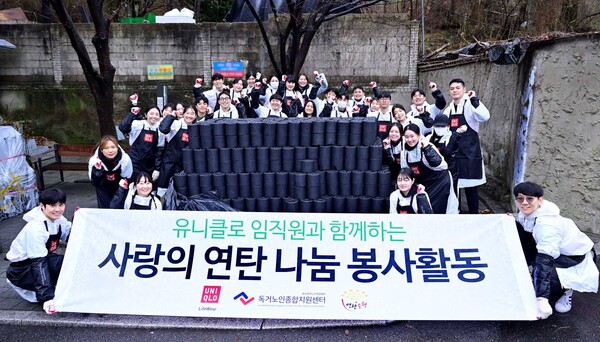 독거노인종합지원센터와 연탄은행을 통해 연탄 5000장을 기부한 유니클로가 14일 직원들과 함께 성북구에서 연탄 배달 봉사에 앞서 기념 촬영을 하고 있다. [유니클로]